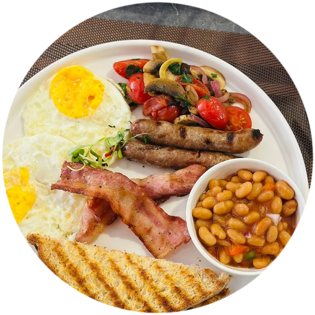 A full breakfast of eggs, bacon, sausage and toast on a white plate