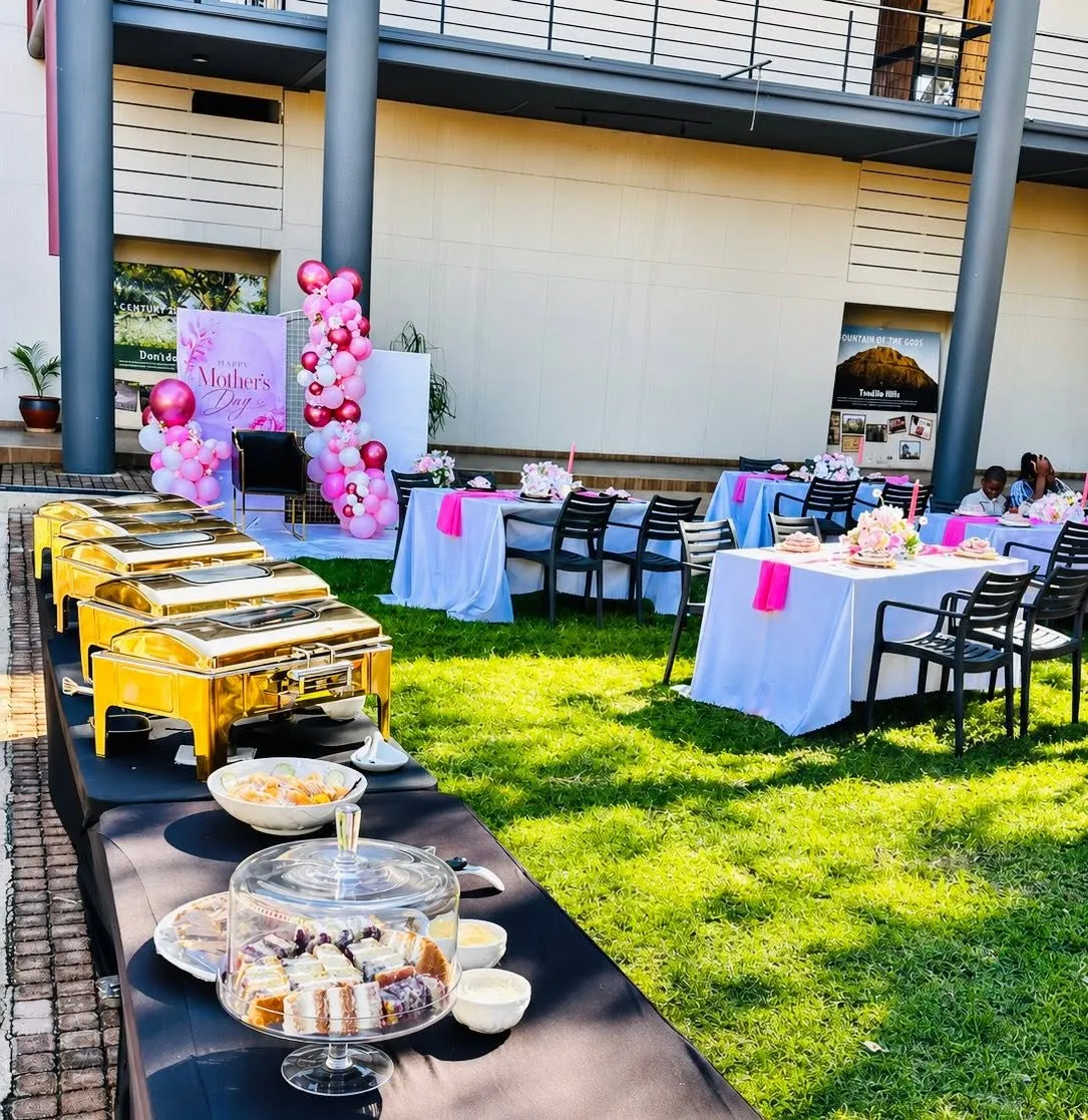 Buffet chafing dishes set out on a table beside the lawn