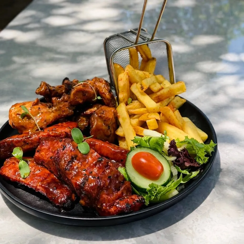 Grilled wings and ribs on a table in the garden