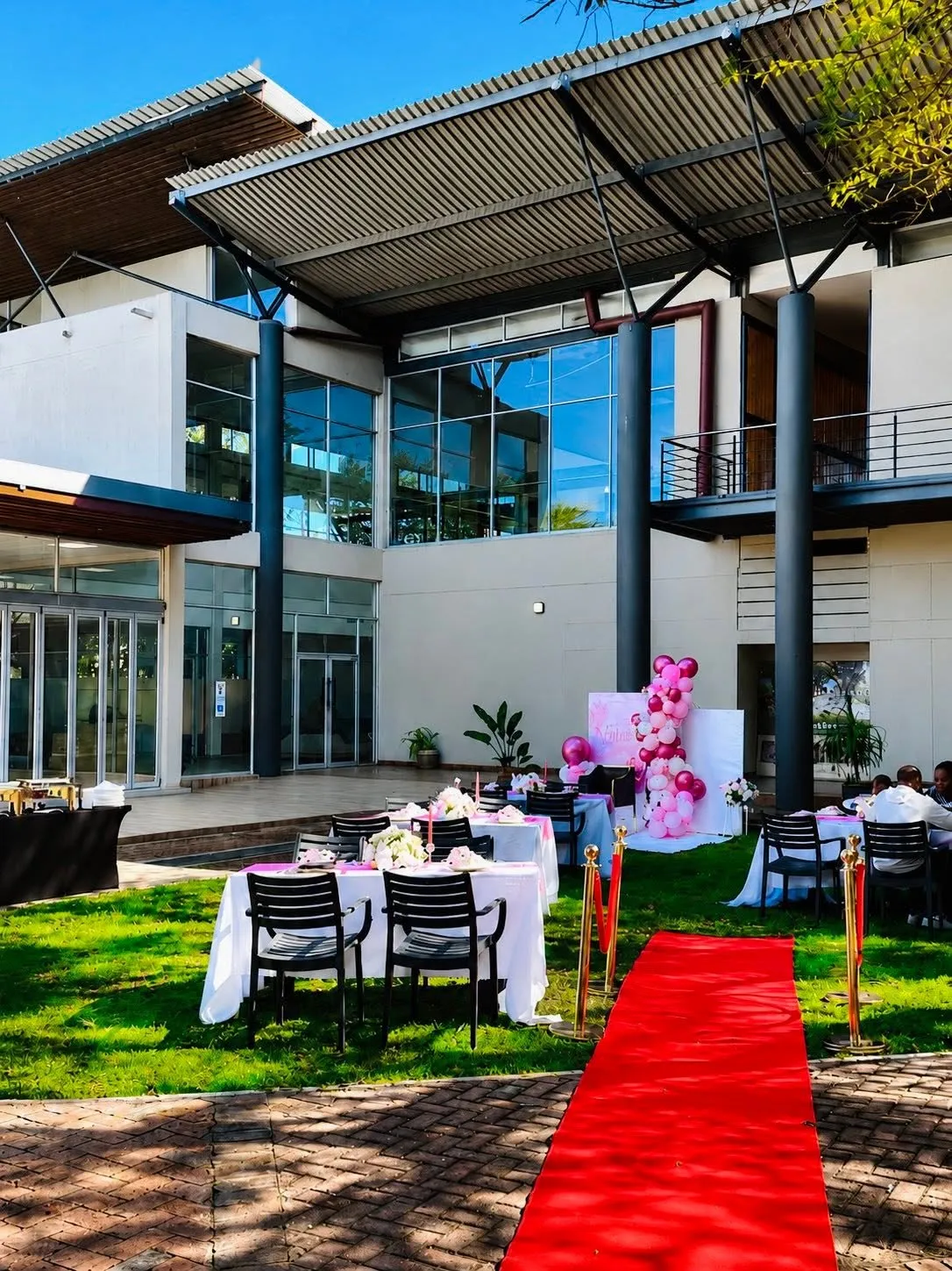 The courtyard styled with dressed tables, flowers and a red carpet