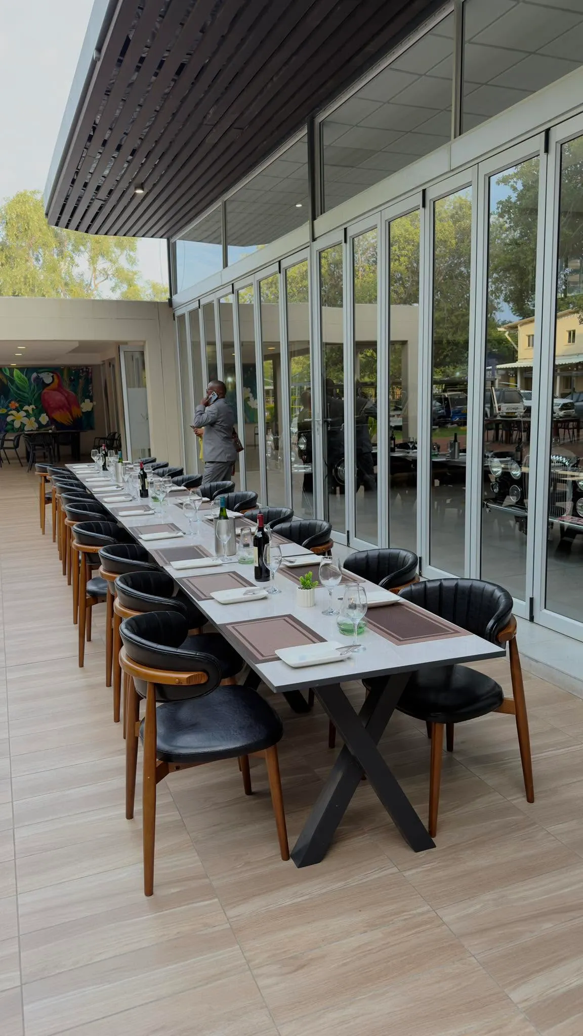 The indoor private dining room with a long table and full-height glazing onto the garden